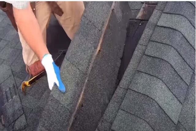 Roofing worker carefuly removing damaged shingle