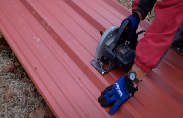 Roofing worker cutting metal roof